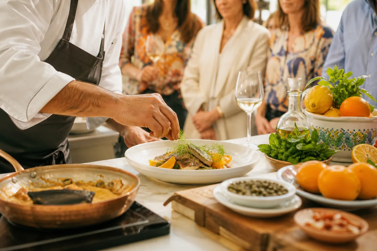 Chef durante un laboratorio di cucina siciliana con agrumi ed erbe